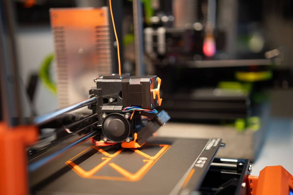 A 3D printer head part-way through building a model