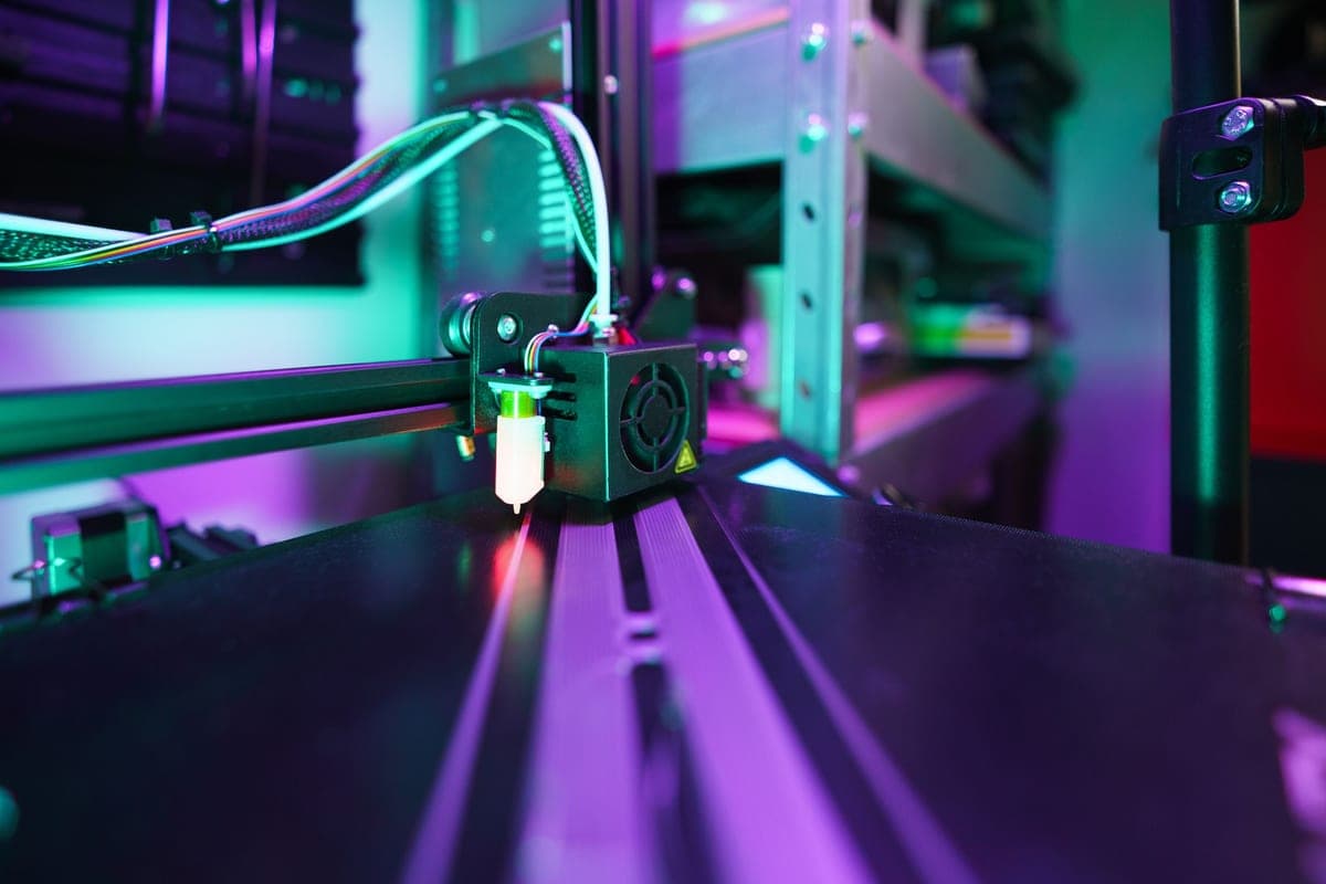 A 3D printer nozzle positioned close above a build plate during calibration