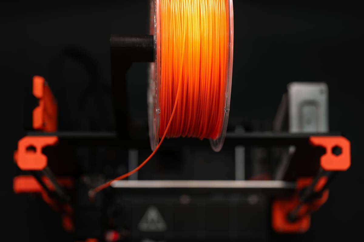 A spool of 3D printer filament photographed close up in a workshop