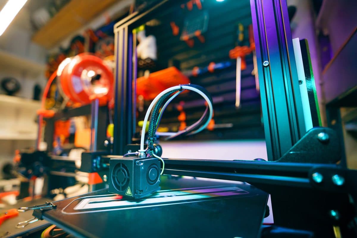 A desktop 3D printer in a workshop, seen close up