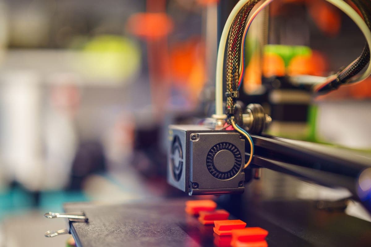 A close view of an open-frame 3D printer's gantry and print head