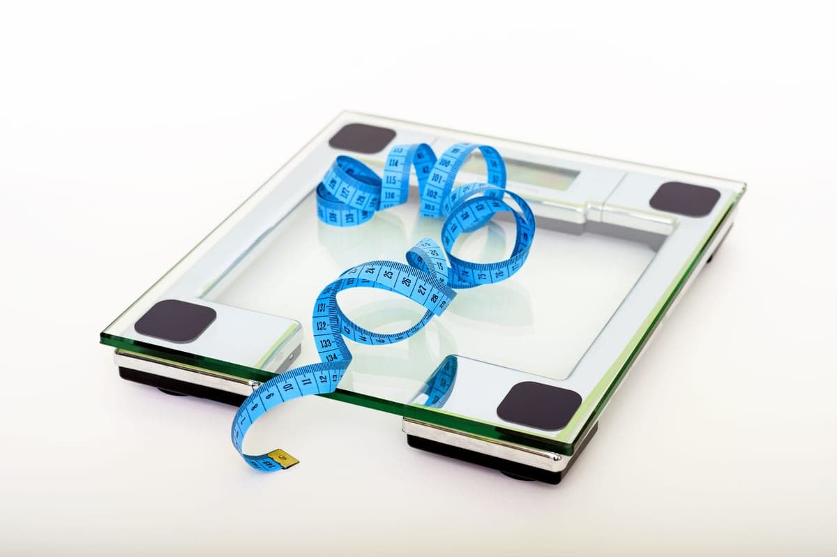 A tape measure resting on a weighing scale