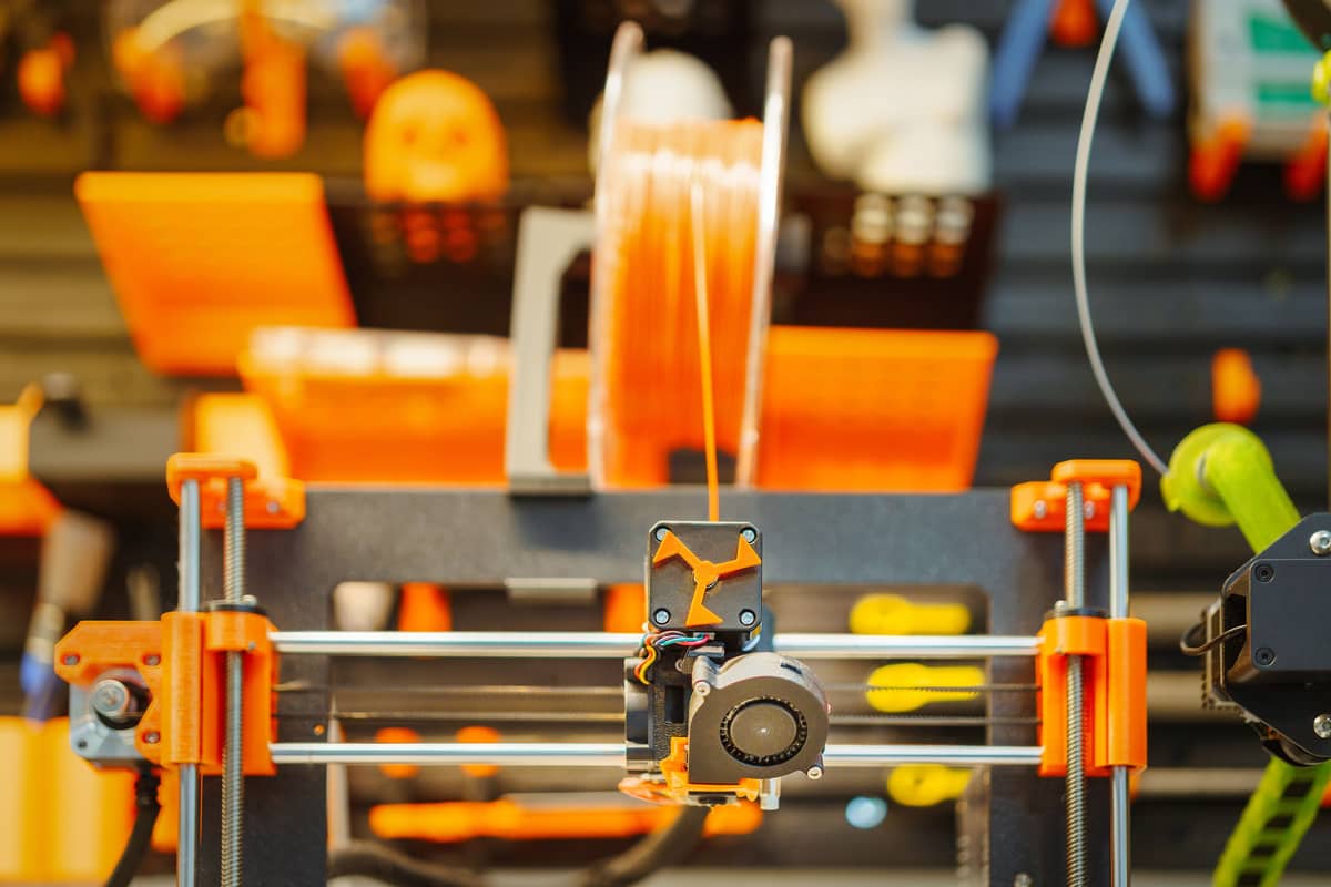A 3D printer extruding filament, photographed close up in a workshop