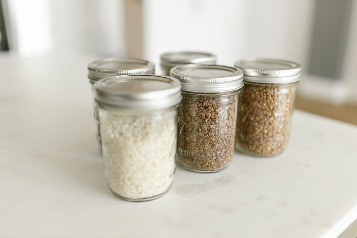 Sealed glass storage jars holding dry goods on a shelf