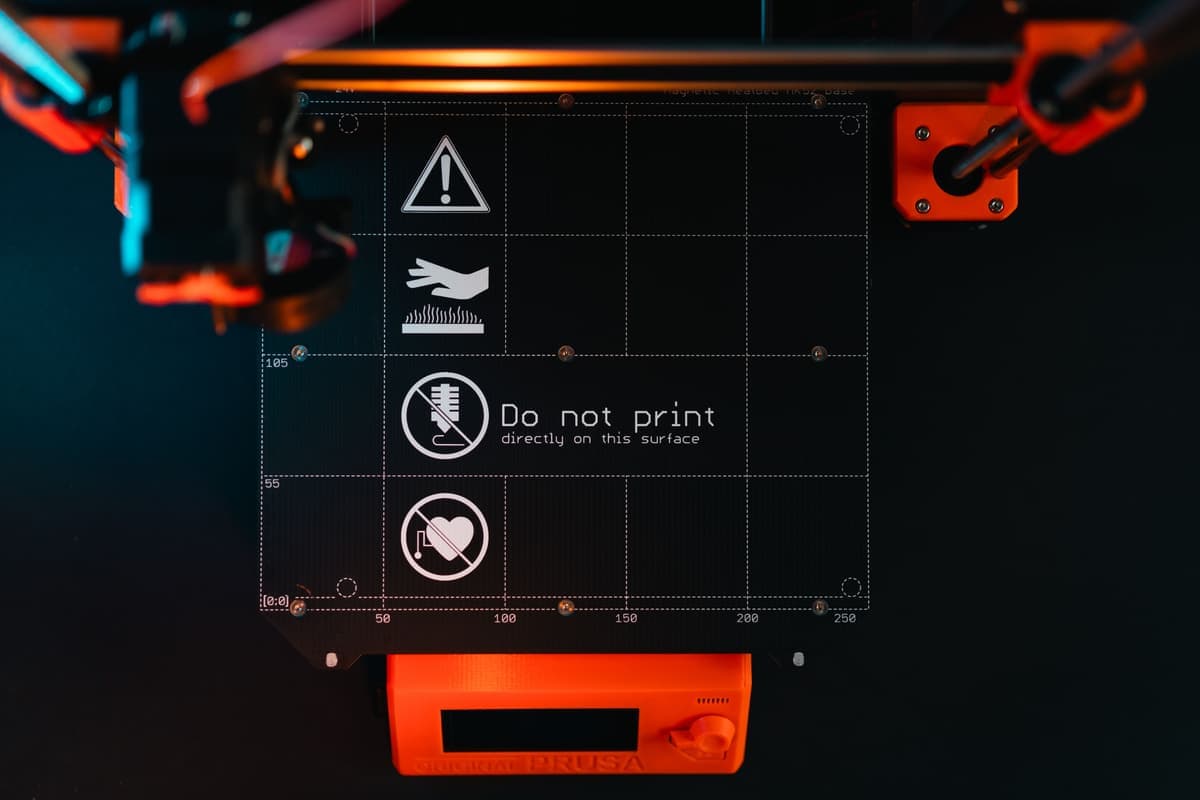The build plate of a 3D printer with warning markings
