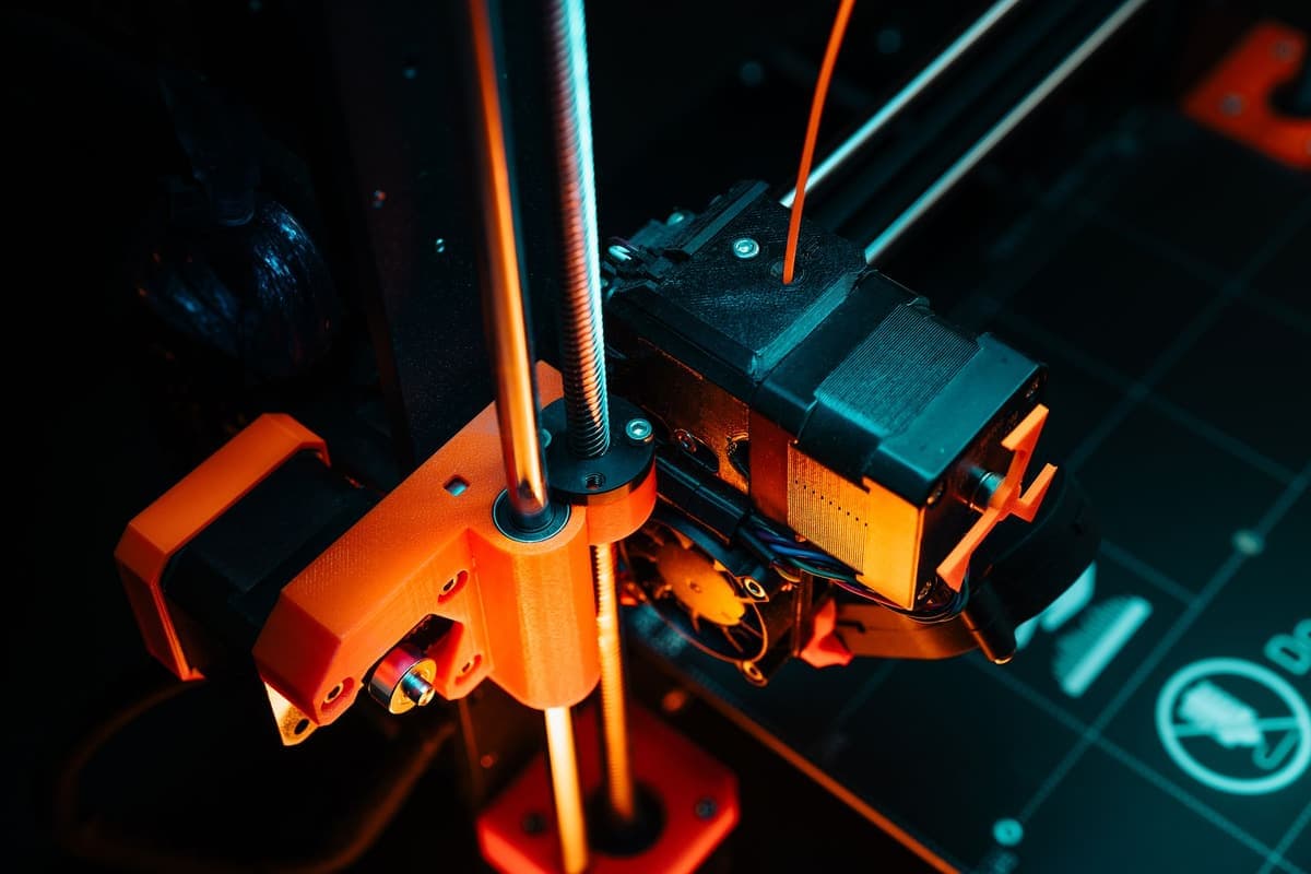 A close-up of a 3D printer mid-print showing the moving mechanism