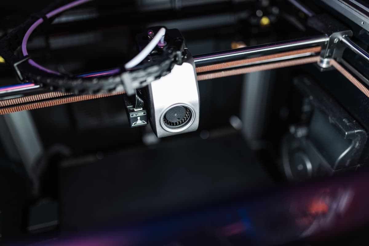 The internal mechanism of a modern enclosed 3D printer, photographed close up