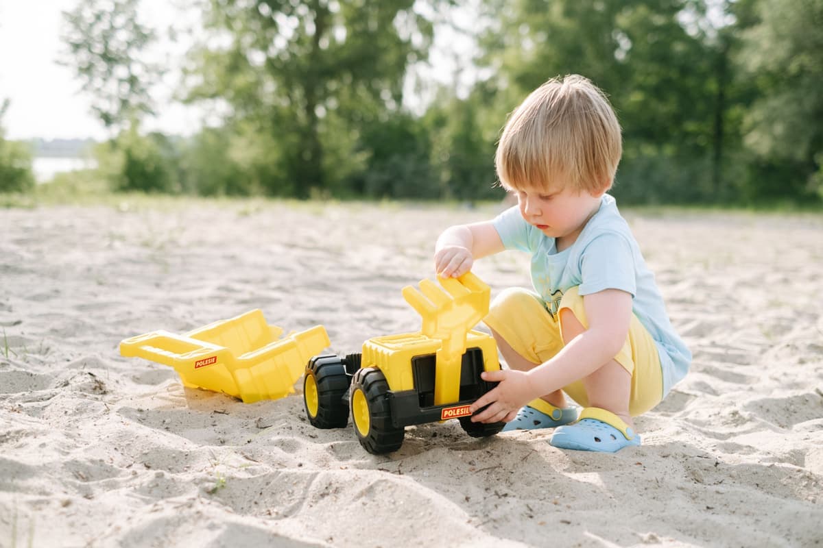 A young child playing with a plastic toy outdoors